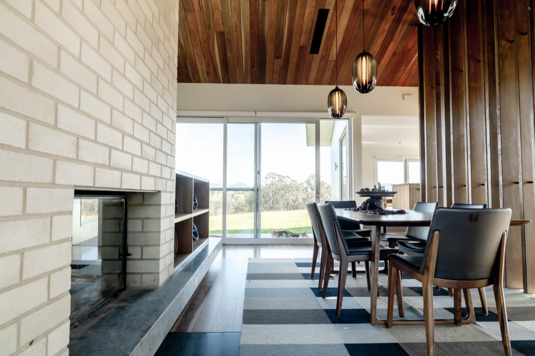 Mogilla Farm dining room with spotted gum ceiling and cream brick fireplace